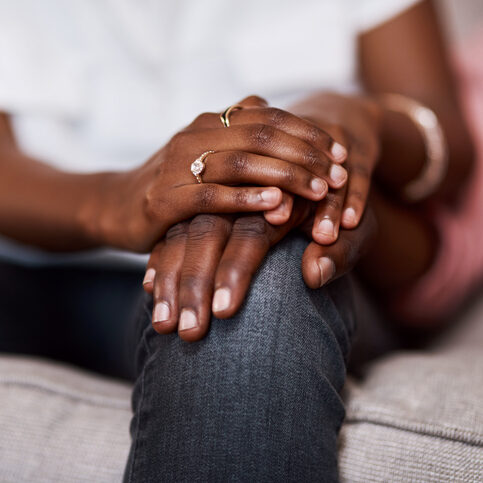Cropped shot of an unrecognizable couple holding hands while sitting together